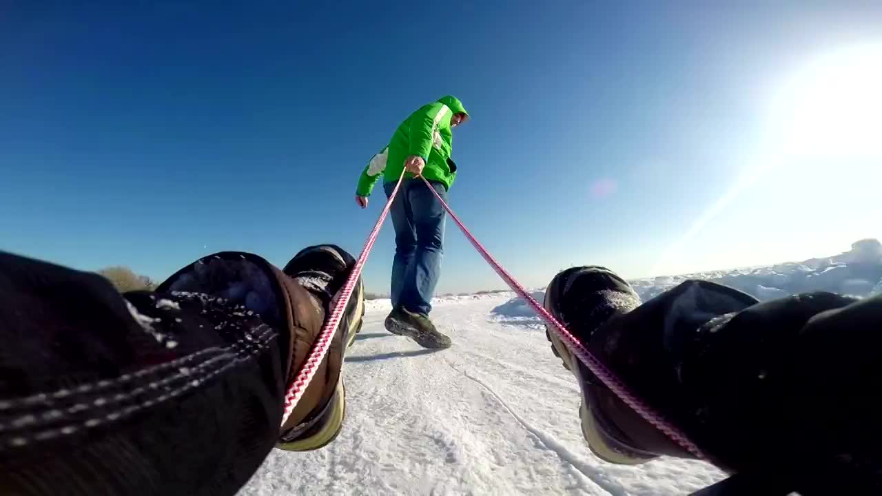 爸爸拉着儿子玩雪橇视频素材