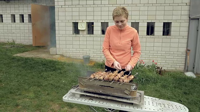 女孩在火盆上用肉烤串视频素材