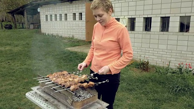 女孩在火盆上用肉烤串视频素材