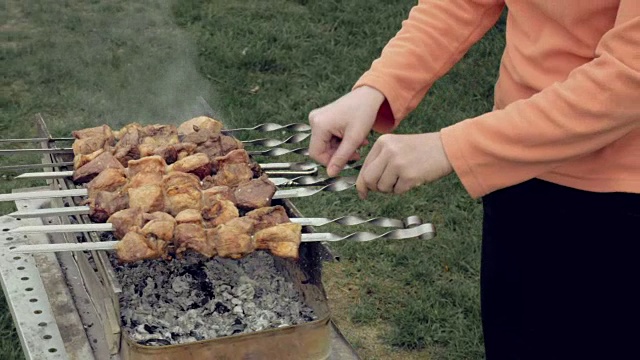 女孩在火盆上用肉烤串视频素材