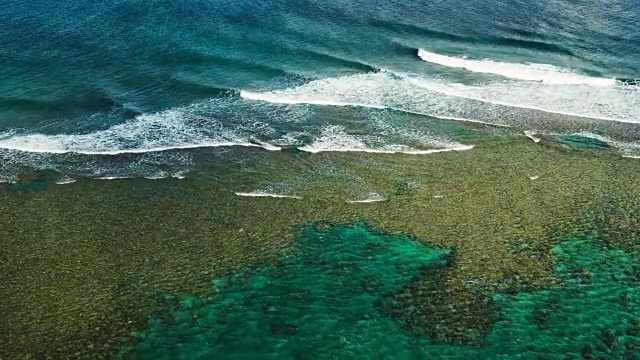 鸟瞰图飞过珊瑚礁和打破海浪视频素材