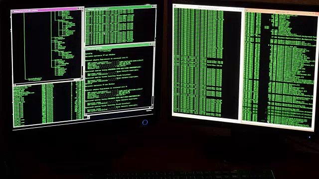 一个黑客分析数据的电脑显示器的特写镜头。黑客犯罪分子从他黑暗的黑客房间侵入网络系统。视频素材