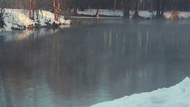 冬季公园里的河。冬天的风景。雪堆在河岸上。寒冷的天气视频素材