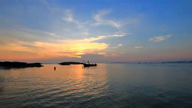 时光流逝黄昏时分，夕阳落在渔船后面视频素材