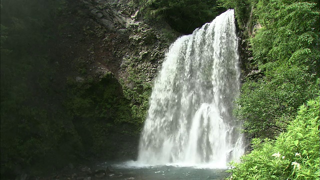 水从岩石上冲进池塘。视频素材