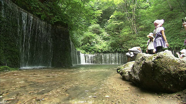 游客们站在Shira'ito瀑布的水池边。视频素材