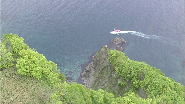 一艘游船沿着沙克坦半岛风景优美的海岸滑行。视频素材