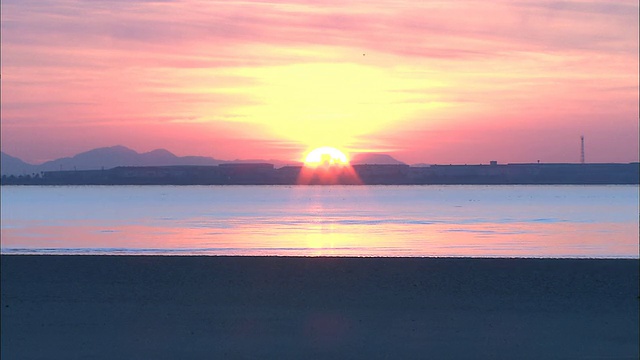 太阳在日本松干海滩附近的地平线上休息。视频素材