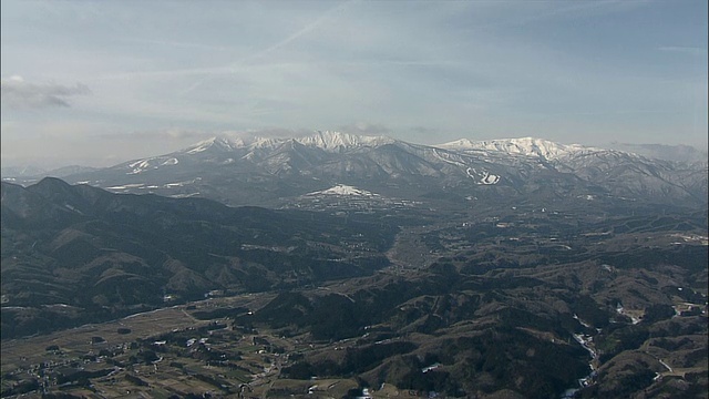 白雪覆盖的灶山俯瞰着一个山谷。空中拍摄视频素材