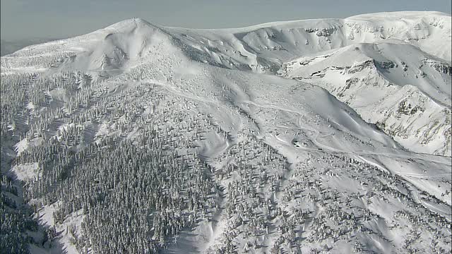 雪上汽车爬着白雪覆盖的山。空中拍摄视频素材