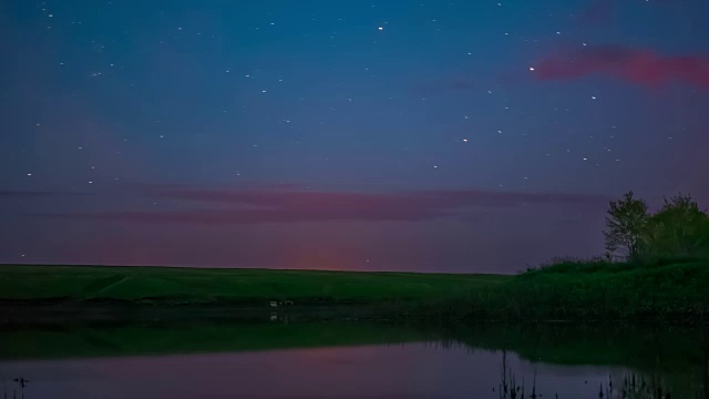 时光流逝视频中旋转的星星在夜空中的岩石河和日出旋转的星星在夜晚的湖上自然睡觉，时光流逝黄昏，美丽的星星夜晚的流星旋转摘录视频素材