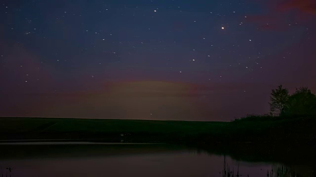 时光流逝视频中旋转的星星在夜空中的岩石河和日出旋转的星星在夜晚的湖上自然睡觉，时光流逝黄昏，美丽的星星夜晚的流星旋转摘录视频素材