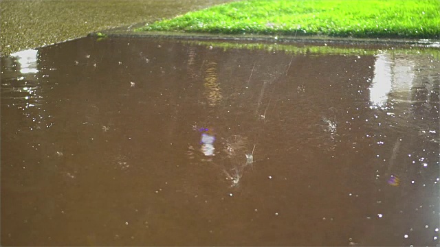 夏天的暴风雨在城市里，雨点飞溅在柏油路上，大自然的美景视频素材