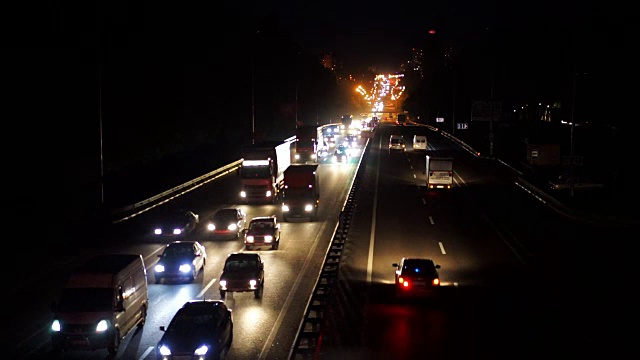 晚上高速公路上交通堵塞，汽车排成长龙缓缓驶出城市视频素材