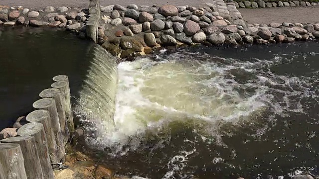 岩石岸边潺潺流淌的瀑布视频素材