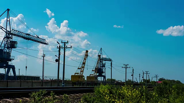 时光流逝和日落剪影的起重机在一个建筑工地装载货物火车铁路工业塔式起重机的货物起重机视频素材