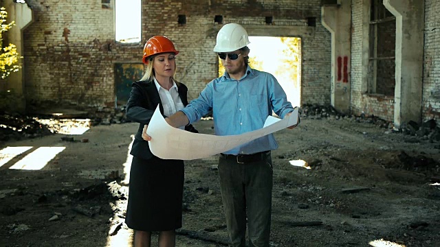 建筑设计师建筑工程师建筑废墟看女孩的工作计划为施工现场施工计划说明在头盔施工头盔女孩看建筑计划和施工计划修复区域视频素材