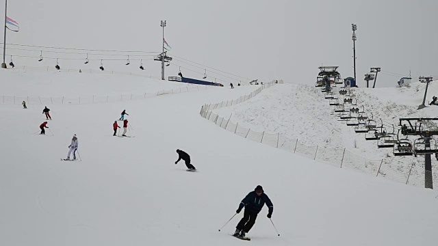 滑雪者和滑雪板运动员向山下滑雪视频素材