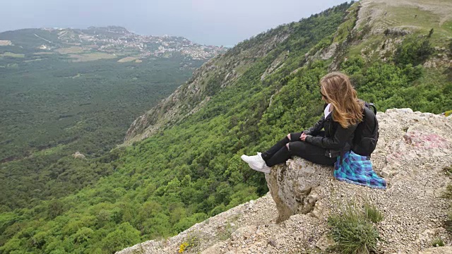 女旅行者看着悬崖的边缘上的海湾山的背景视频素材