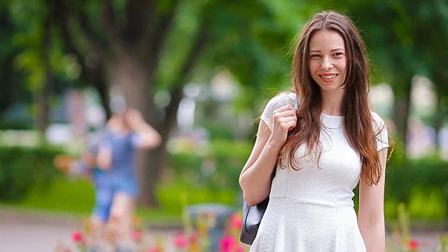 美丽的年轻女子肖像户外。快乐美丽的女人在公园微笑的肖像视频素材