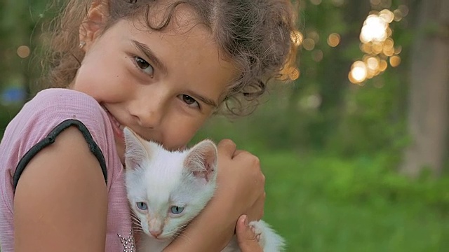 黑发女孩抱着小猫在她的猫怀里爱少年户外视频素材