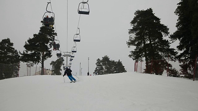 滑雪者和滑雪板运动员向山下滑雪视频素材