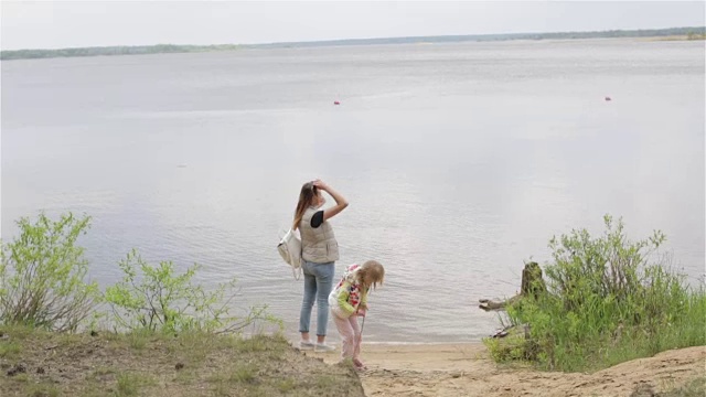 孕妇和小女孩们在森林湖边的海滩上。视频素材