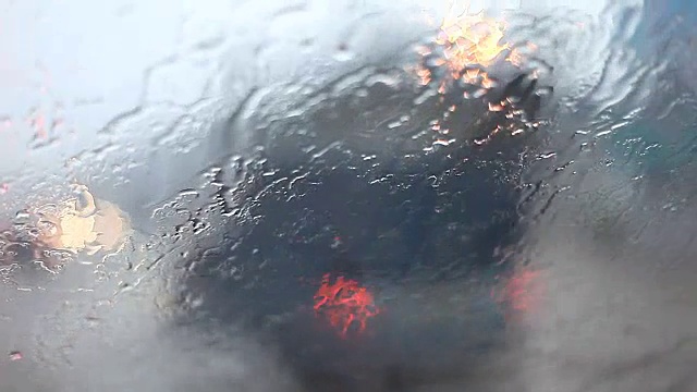 天气不好，路上下着雨。湿滑的路，雨点落在挡风玻璃上。能见度低的交通。视频下载