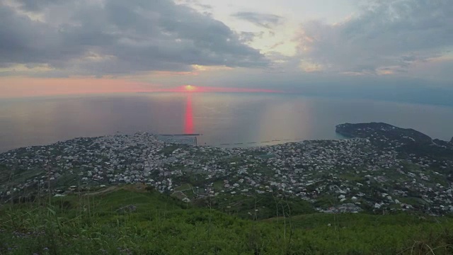 海上日落时间的流逝，令人难忘的景观，位于山的城市，旅游视频素材