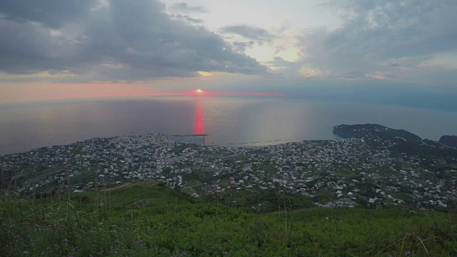 夕阳下，金色的阳光沉于海中，城市灯光的时间流逝，晚霞视频素材