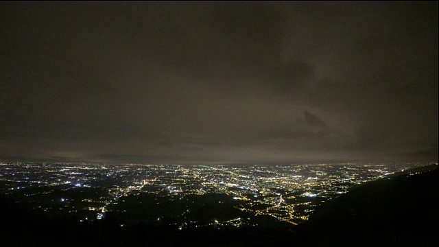 厚重的山云的时间推移，夜幕下的城市躺在海边视频素材