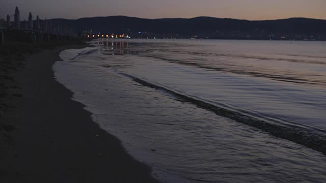 太阳从地平线升起，清晨沙滩上的海浪视频素材