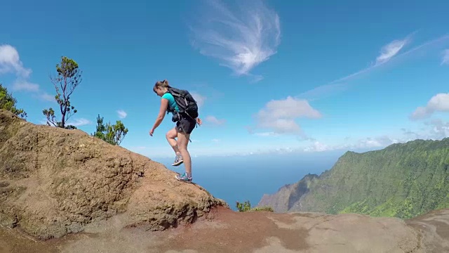 活跃的年轻女子走在小径上的山脊与令人惊叹的景色视频素材