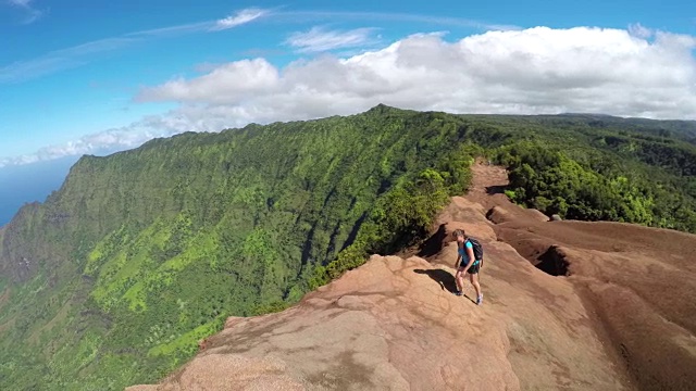 活跃的年轻女子走在高山路与惊人的海景视频素材