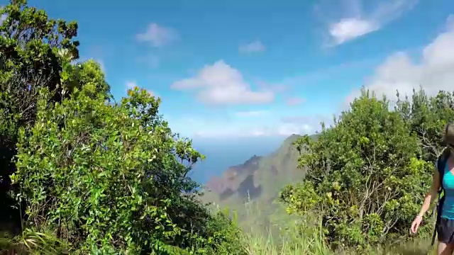 特写:在阳光明媚的夏威夷，一名女子走在丛林山路上视频素材