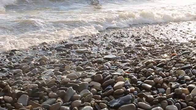 随着太阳的落山，海浪慢慢地冲上海滩，慢慢地退去。视频素材