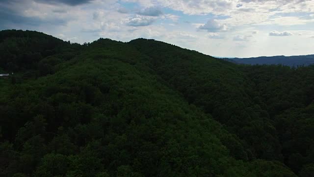 绿色的森林和山脉映衬着蓝天，鸟瞰图视频素材