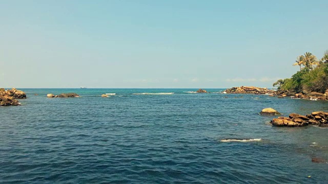 壮丽的海景，在炎热的夏日，光波拍打着岩石视频素材