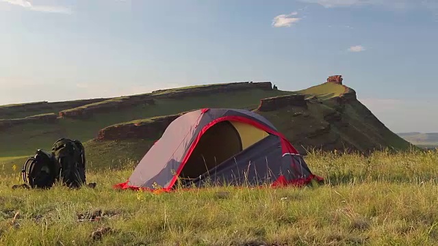 夏天游客在山上的草地上搭帐篷。视频素材