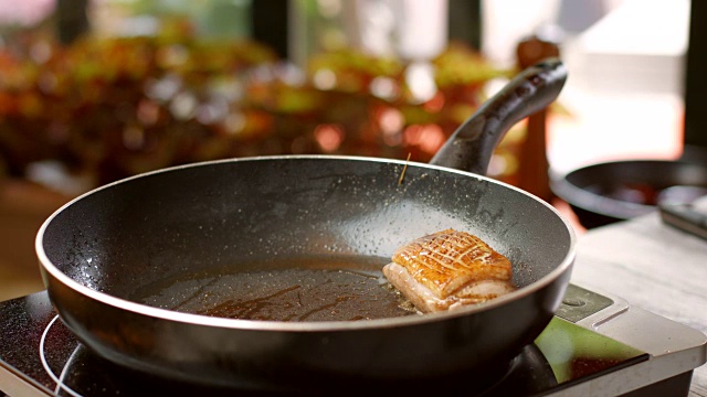 肉和香草放在锅里。瓶子把液体倒在肉上。视频素材