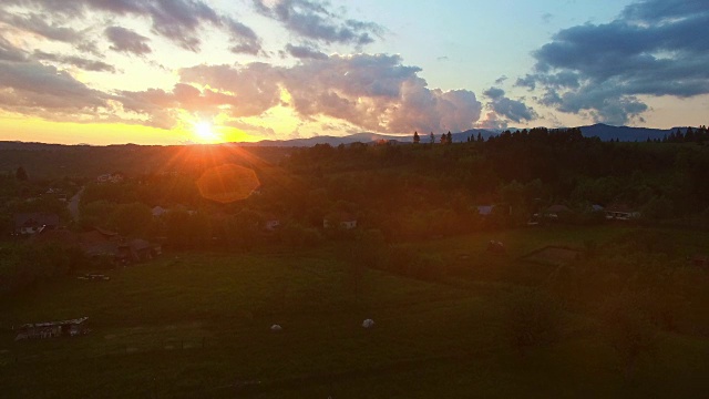 苍翠的山峦和乡村的村落在夕阳下，倾斜着视频素材