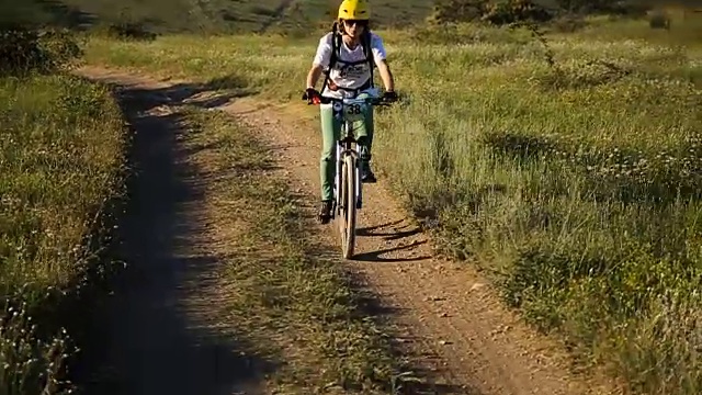 女自行车手骑着山地车在山路上骑行视频素材