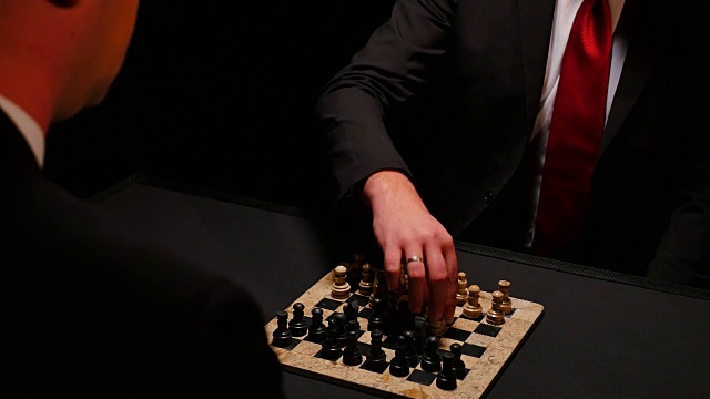 两个成年人在一间黑暗的房间里下棋视频素材