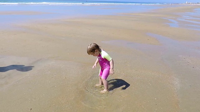 婴儿在海滩上跳水坑视频素材