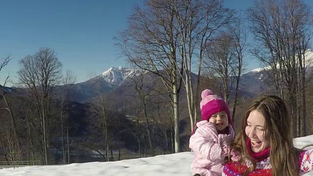 妈妈和她漂亮的女儿在冬天。慢动作视频素材