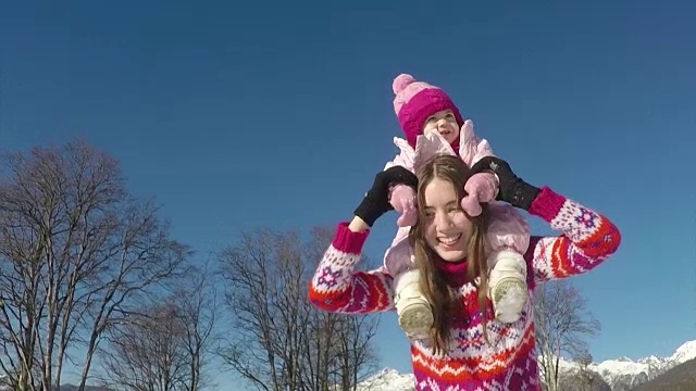 妈妈和她漂亮的女儿在冬天。慢动作视频素材