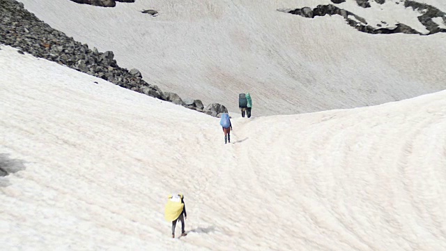 一群背着徒步背包的游客来到高加索地区的高雪山上视频素材