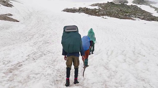 一群背着徒步背包的游客来到高加索地区的高雪山上视频素材