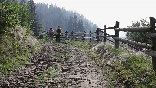 一对背包客在山路上徒步旅行视频素材