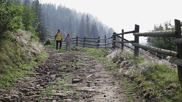 一对背包客在山路上徒步旅行视频素材